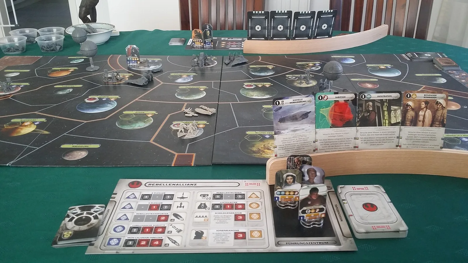 Star Wars: Rebellion set up on a table, with the galaxy board, miniatures, mission cards and the Rebel faction sheet
